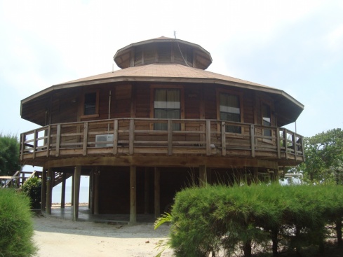 A pretty circular wooden house right on the beach.