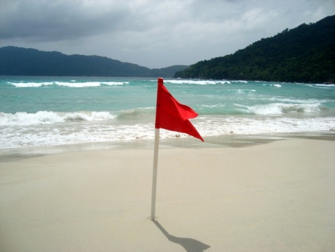 Red flag on Long beach. A warning of strong currents and waves. 