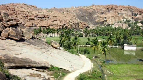A view from above, flooded paddy fields, surrounded by boulder rocks on Hampi Island.