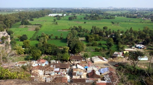 The view of the nearby village surrounded by fields.